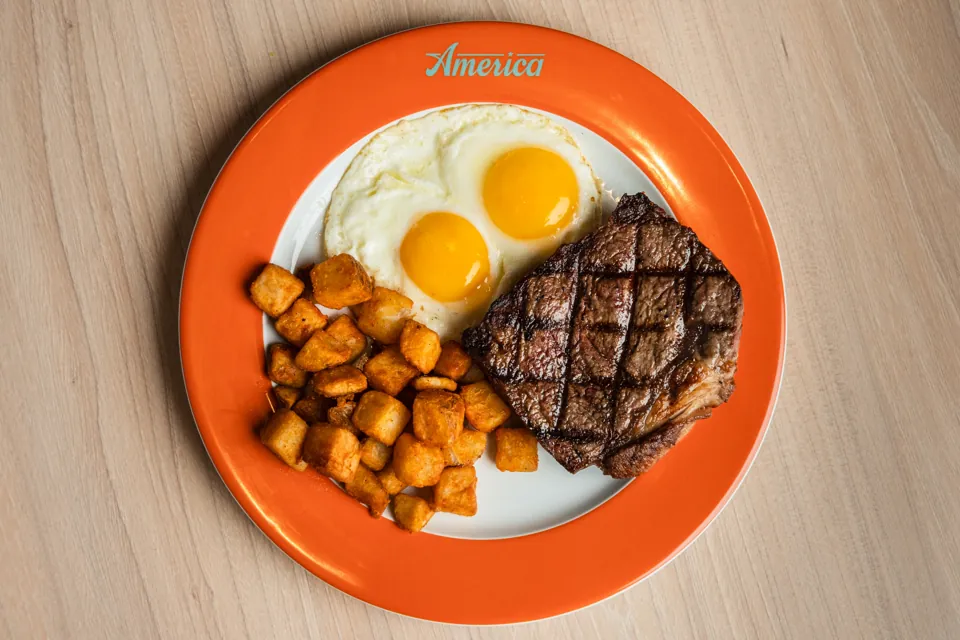 Steak con huevos y papas servido en America de New York-New York
