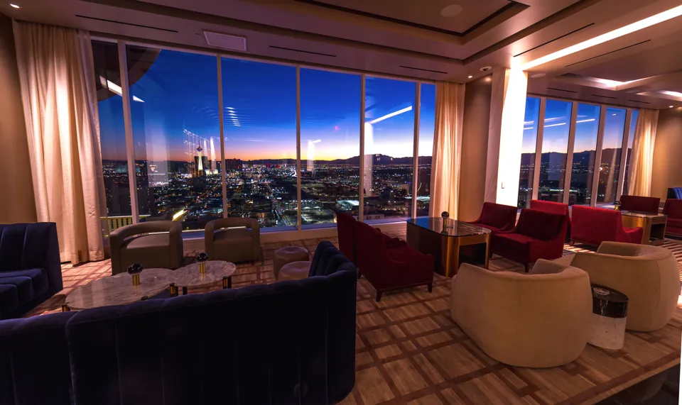 Asientos y ventanales de Legacy Club en Circa al atardecer