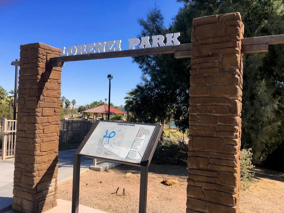 Arco de entrada con el nombre Lorenzi Park y un panel del parque.