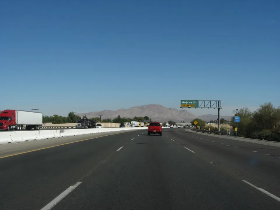 Carretera I-15 con vehículos y señal de salida a Mojave Drive.