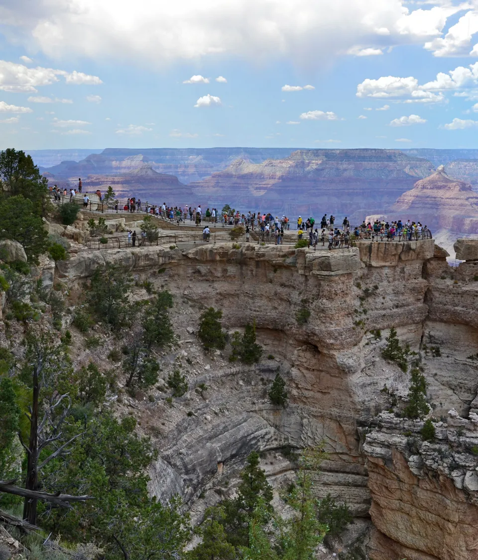 Mirador de Mather Point con visitantes y el paisaje del South Rim del Gran Cañón al fondo.