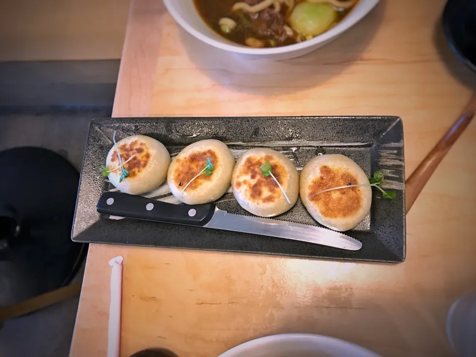 Cuatro piezas doradas de Beef Pancake sobre un plato rectangular de Shàng Artisan Noodle, según el fotógrafo.