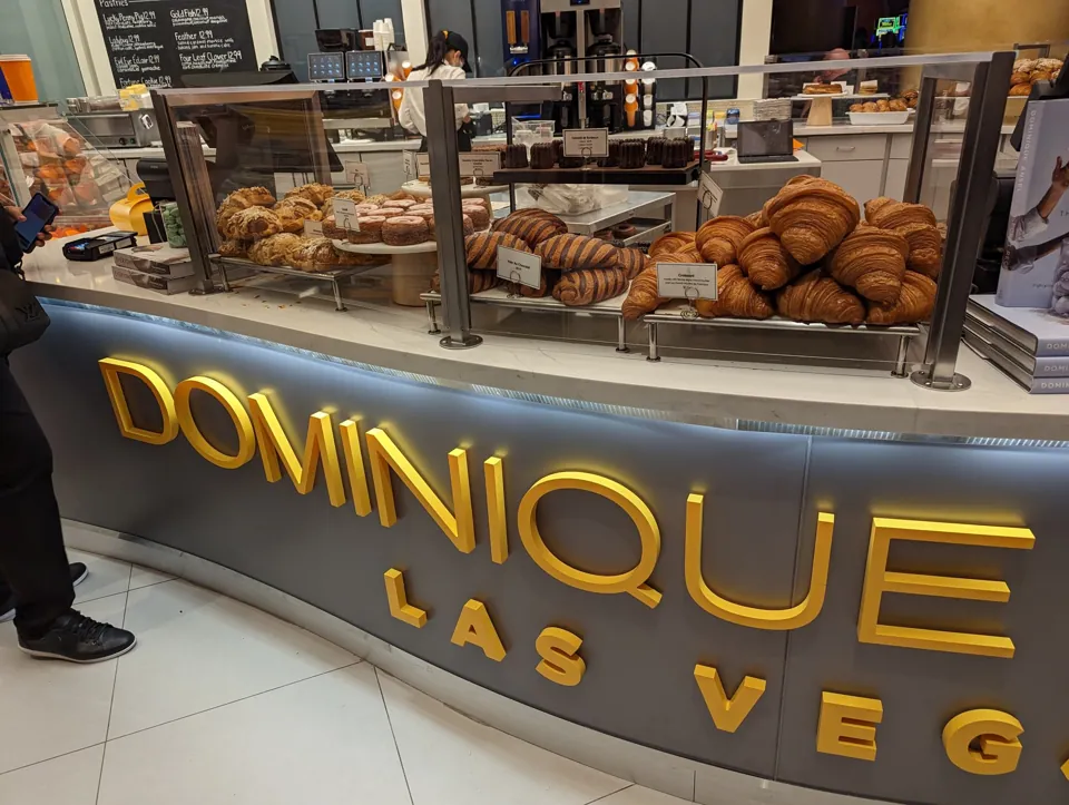 Vitrina de pastelería con croissants y letrero de Dominique Ansel Las Vegas.