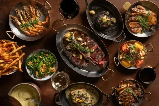 Mesa con platillos de Tom Colicchio’s Craftsteak en MGM Grand · imagen editorial del operador, sin fecha de toma publicada; menú y presentación pueden variar.