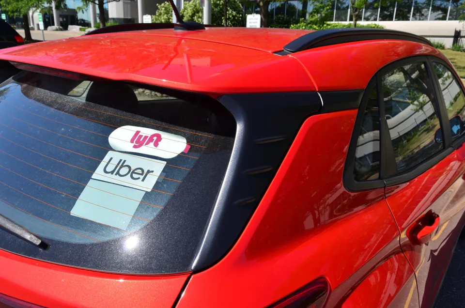 Distintivos de Uber y Lyft en el vidrio trasero de un automóvil
