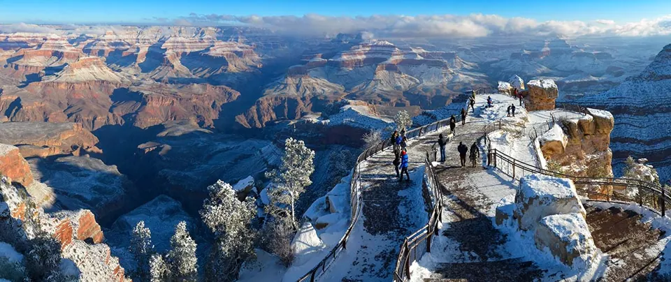 Mirador Mather Point y capas del Grand Canyon con nieve en primer plano.