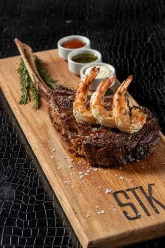 Bone-in ribeye de STK; presentación y menú sujetos a cambios.