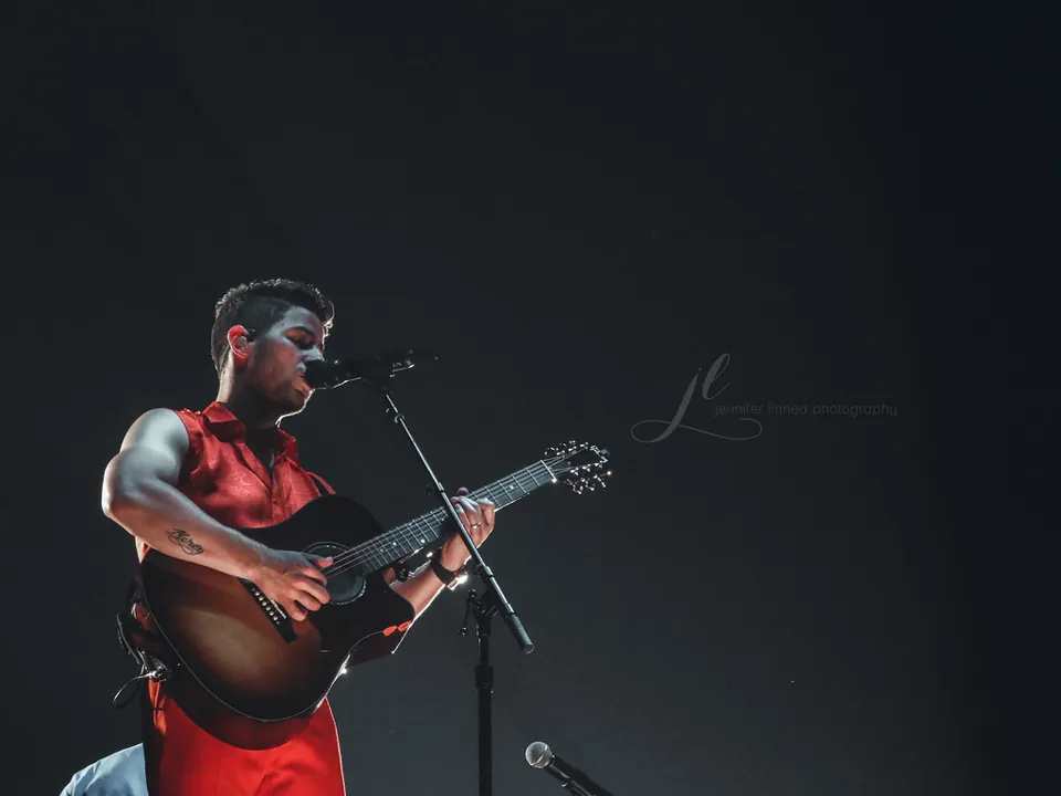 Nick Jonas toca guitarra y canta durante un concierto de Jonas Brothers en Denver en 2019.